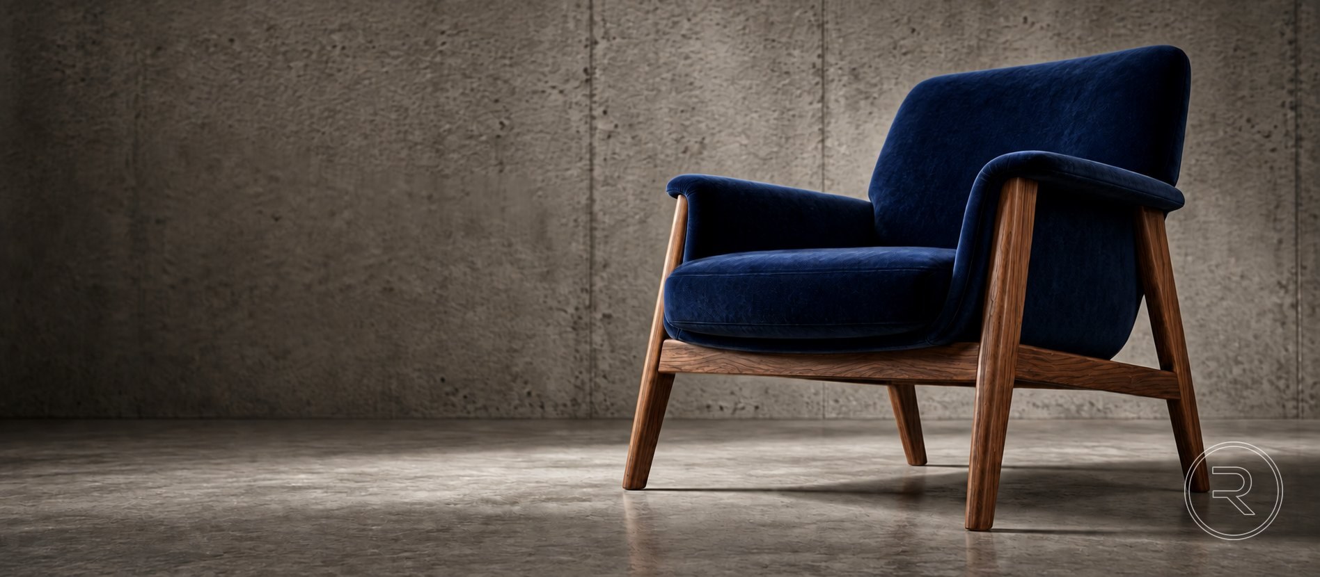 Sillón tapizado en terciopelo azul con estructura de madera, frente a un muro de concreto.